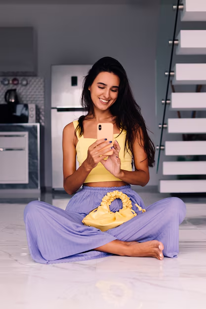 Smiling woman sitting on the floor using her phone, next to a list explaining why people buy Instagram comments and trust SocioTraffic for real engagement.
