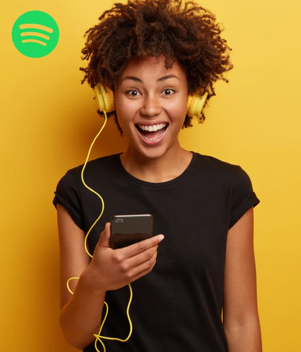 Excited woman discovering new music, showing the buzz you get when you buy Spotify monthly listeners cheap