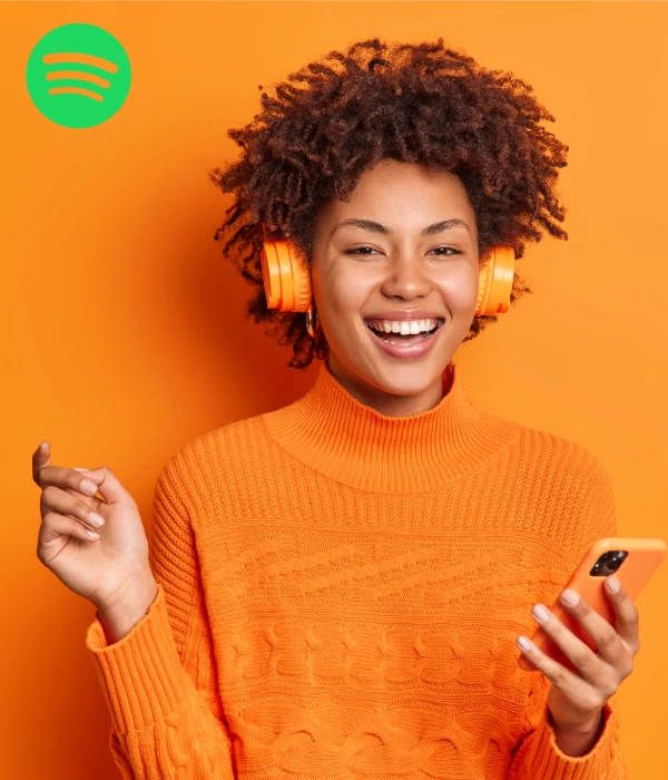 Happy listener enjoying music with headphones, symbolizing the impact when you buy Spotify monthly listeners