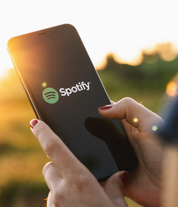 Person opening Spotify app outdoors, symbolizing the start of their journey to buy Spotify streams for better music visibility.