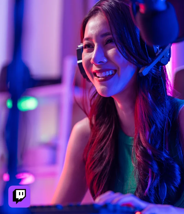 Female gamer live streaming with headset and RGB lighting, representing creators who buy Twitch viewers to grow their audience faster