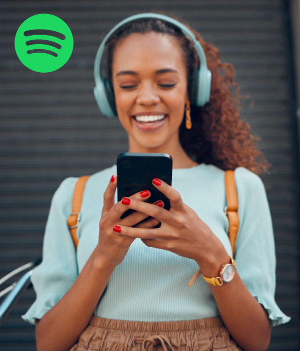 Happy listener enjoying tracks on her phone, reflecting the results musicians hope for when they buy plays on Spotify or boost their streams.