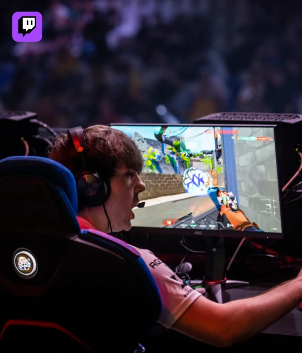 Pro gamer mid-match at a tournament, reacting to gameplay while streaming